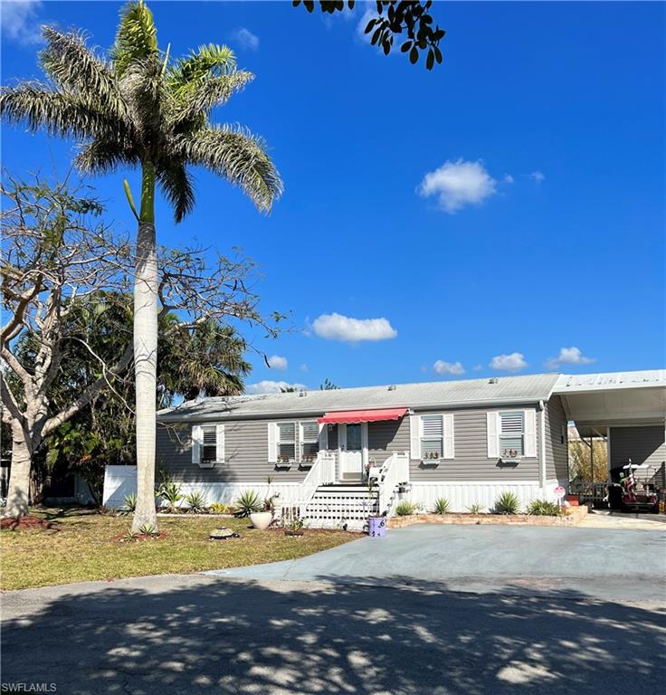 6 Cannes Drive Naples, FL 34112 - Photo 3 of 21 a front view of a house with a garden and patio