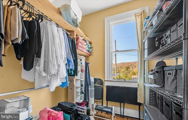 a view of walk in closet with clothes and shoes