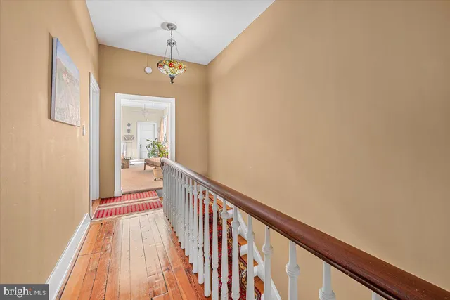 a view of a hallway with wooden floor and staircase