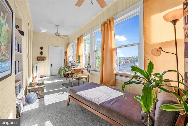 a living room with furniture and large windows