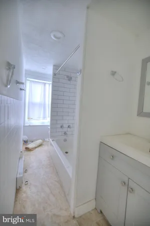 a bathroom with a granite countertop sink a toilet and shower