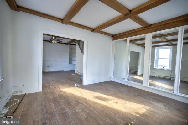 an empty room with wooden floor and mirror