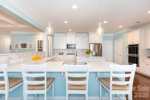 a kitchen with a dining table chairs and white cabinets