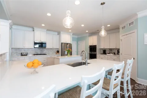 a kitchen with a dining table chairs refrigerator and microwave