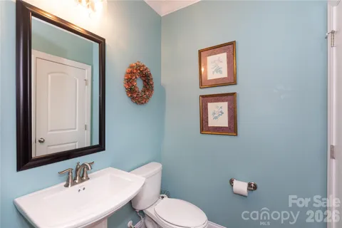 a bathroom with a toilet a sink and mirror