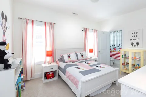 a bedroom with a bed a dresser and a window