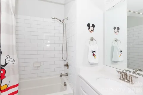 a bathroom with a bathtub sink vanity and shower