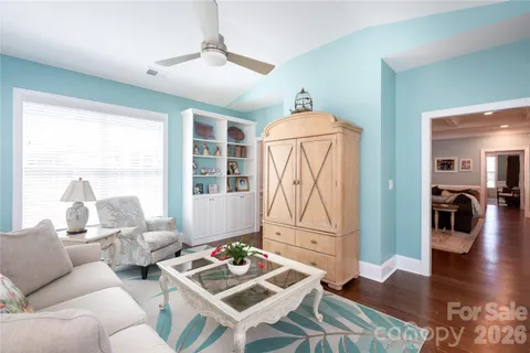 a living room with furniture a table and wooden floor
