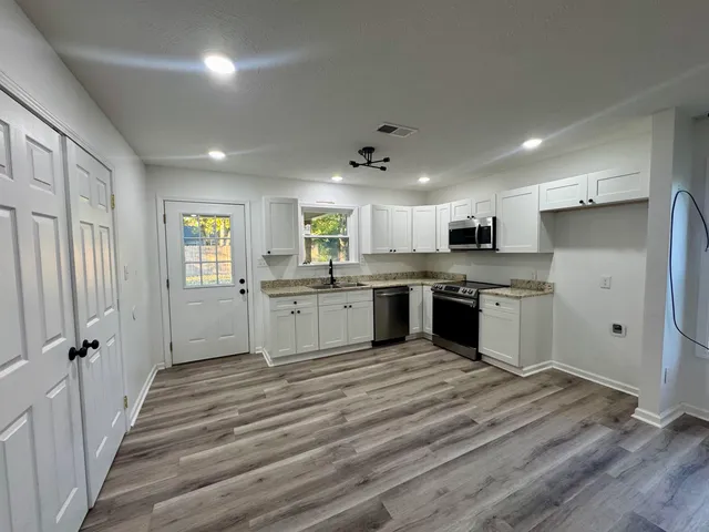 a large kitchen with a large window and stainless steel appliances