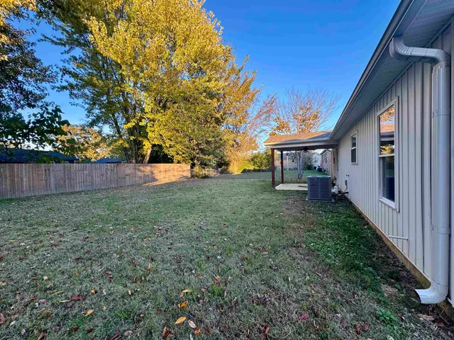 a view of a house with backyard and a tree