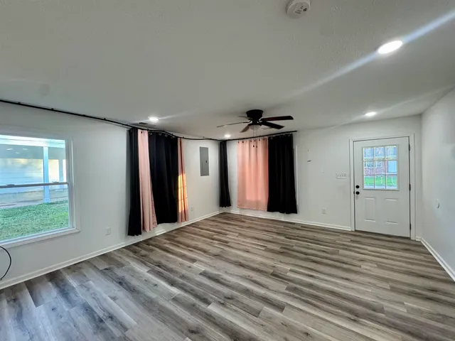 a view of a livingroom with wooden floor and windows