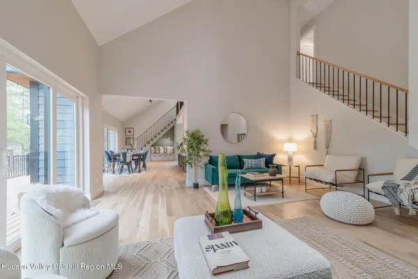 a living room with furniture a large window and a wooden floor