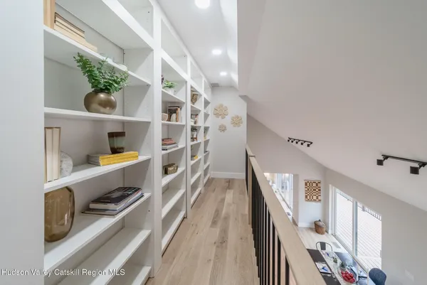 a view of walk in closet with wooden floor and a potted plant