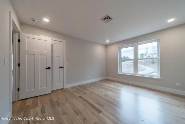 a view of a hallway with wooden floor and furniture
