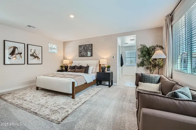 a bedroom with a large bed couch and a window