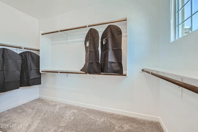 a view of walk in closet with clothes