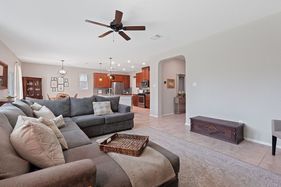a living room with furniture and a ceiling fan