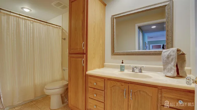 a bathroom with a double vanity sink toilet and a mirror
