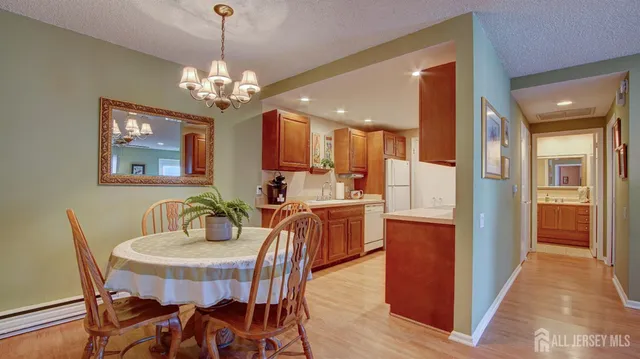 a view of a dining room with furniture a chandelier and wooden floor