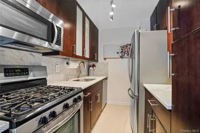 a kitchen with stainless steel appliances granite countertop a refrigerator stove and sink