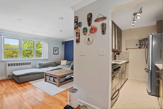 a living room with stainless steel appliances furniture and a window