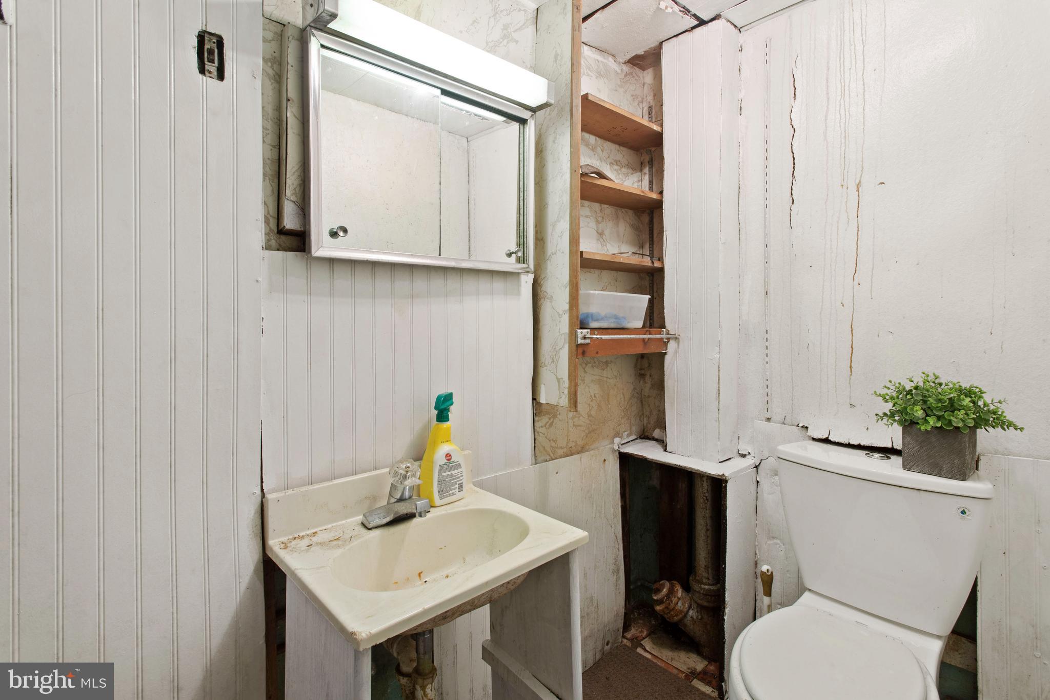 5425 Whitlock Road Baltimore, MD 21229 - Photo 11 of 30 a bathroom with a sink toilet and mirror
