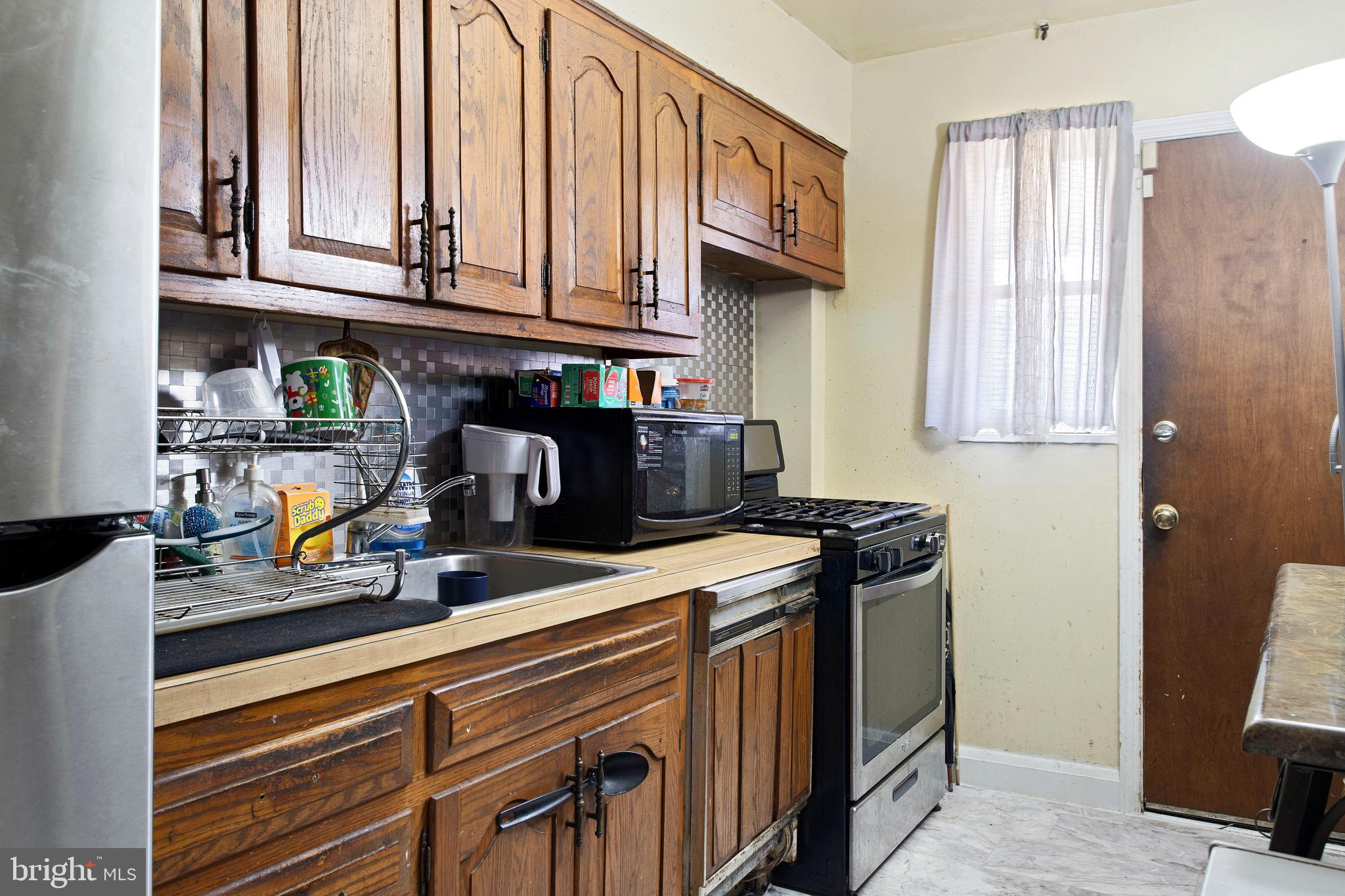 5425 Whitlock Road Baltimore, MD 21229 - Photo 10 of 30 a kitchen with stainless steel appliances granite countertop a sink a stove and a microwave