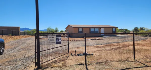 a view of a yard with wooden fence