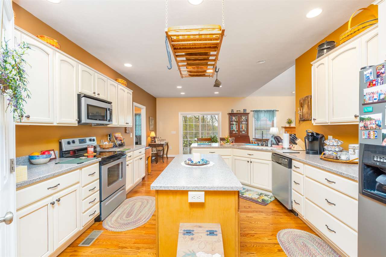283 Round Hill School Road Fort Defiance, VA 24437 - Photo 22 of 48 a large kitchen with stainless steel appliances granite countertop a stove a sink dishwasher and white cabinets with wooden floor