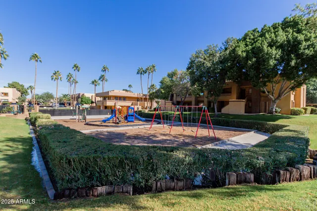 a view of a swimming pool with a yard and palm trees