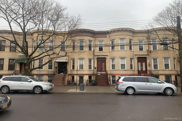 a view of a cars parked in front of a white house