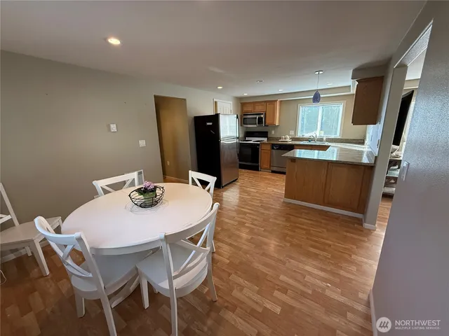 a view of a dining room with furniture and a kitchen