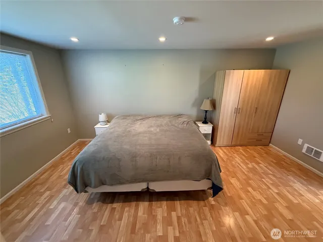 a bedroom with a bed and wooden floor