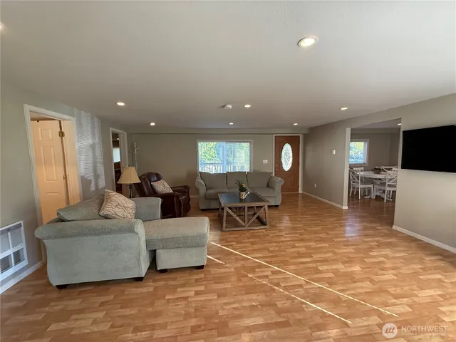 a living room with furniture and a dining table with kitchen view
