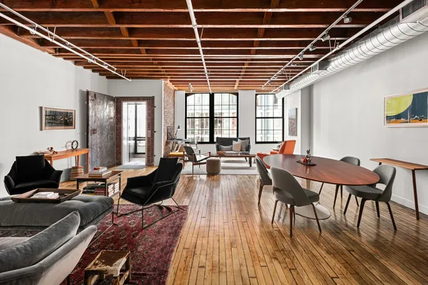 a living room with furniture a wooden floor and next to a window