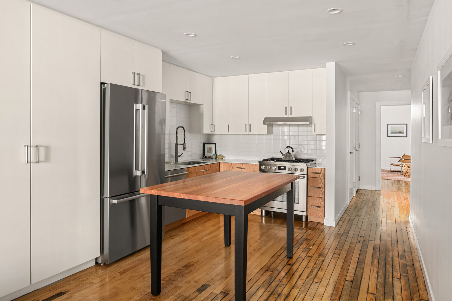 554 Broome Street, Unit 4 Manhattan, NY 10013 - Photo 4 of 13 a kitchen with stainless steel appliances granite countertop a refrigerator a stove and a wooden floors