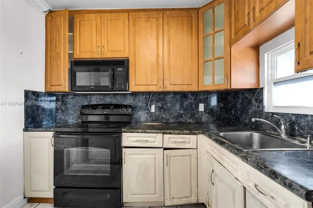 a kitchen with granite countertop a sink and a stove