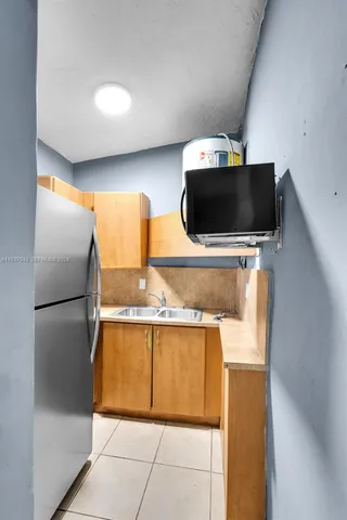 a living room with a flat screen tv and a refrigerator