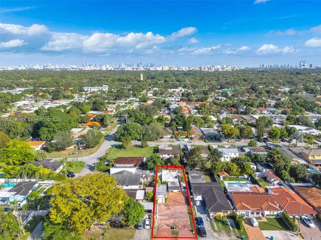 an aerial view of residential houses with outdoor space and trees