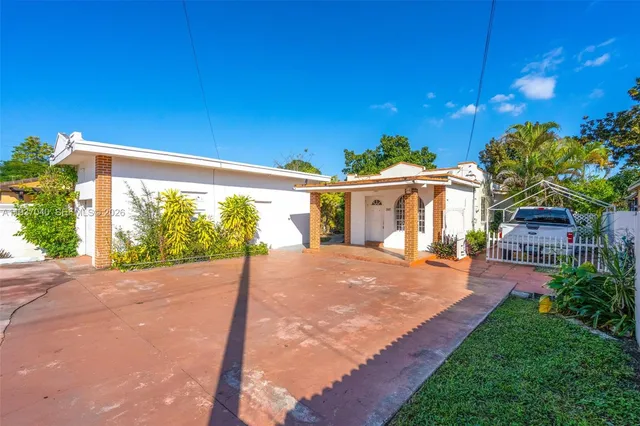 a view of a house with backyard and a tree
