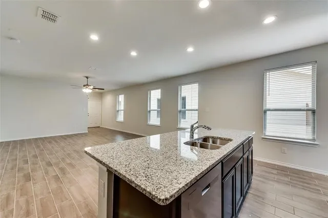 a large kitchen with stainless steel appliances granite countertop a stove a refrigerator a sink a microwave and wooden cabinets