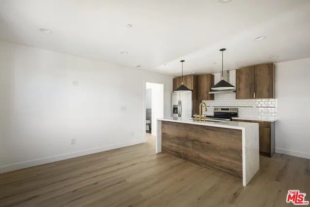 a kitchen with stainless steel appliances a stove top oven a sink and white cabinets
