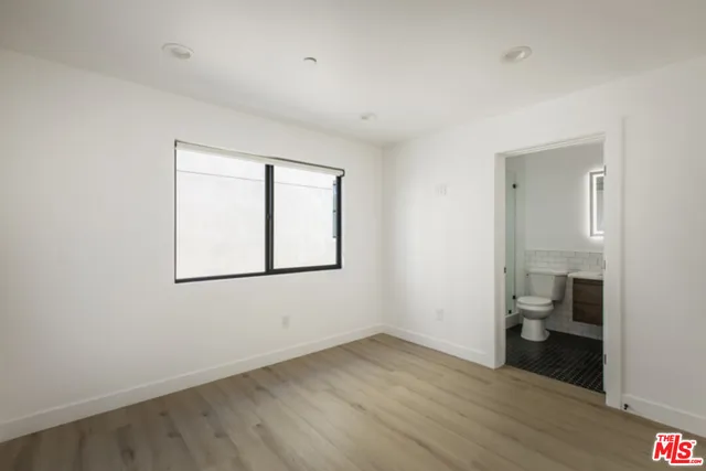 wooden floor in an empty room with a bathroom
