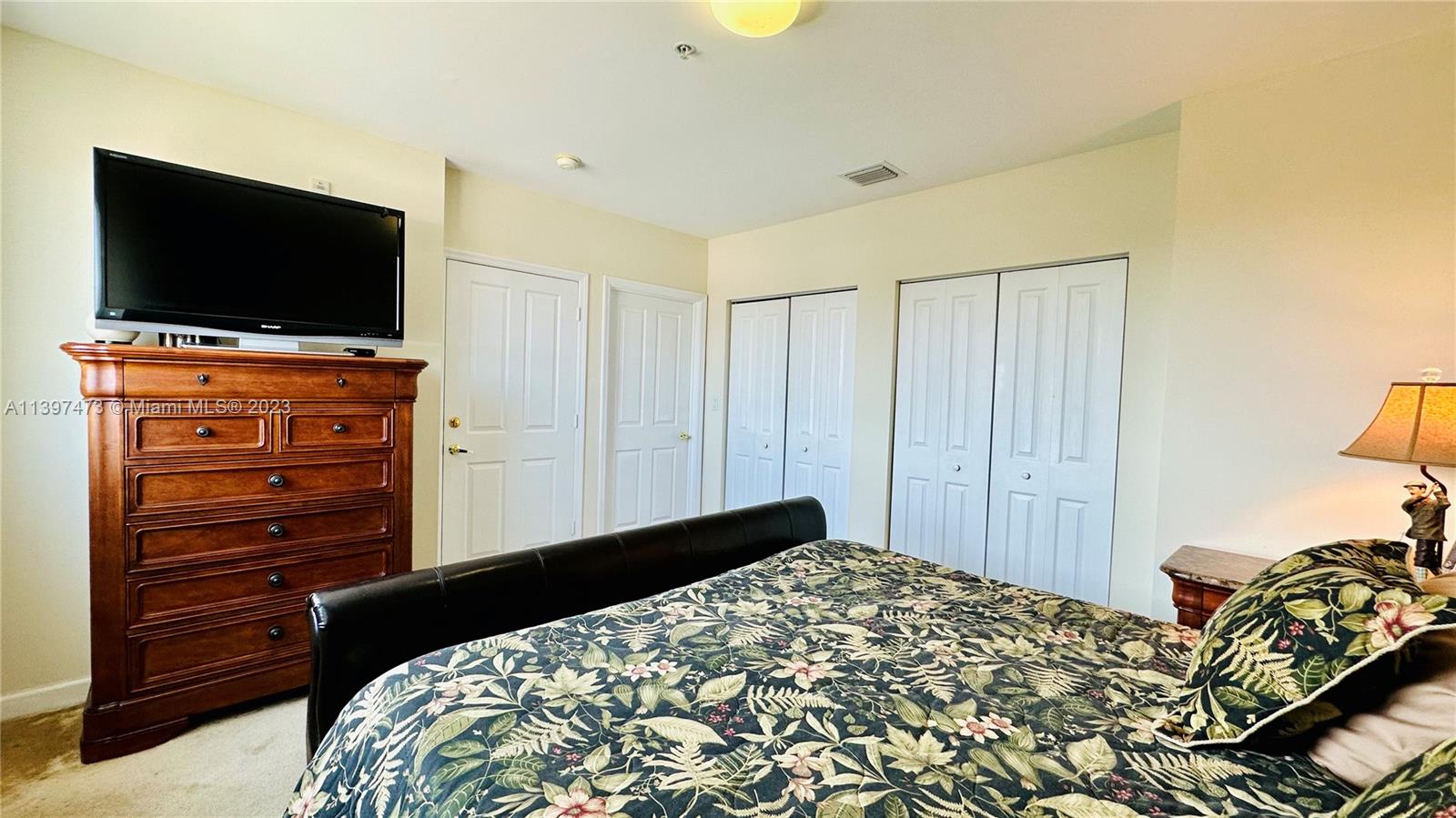 2280 Southwest 32nd Avenue, Unit 315 Miami, FL 33145 - Photo 14 of 21 a bedroom with a bed and a flat tv screen