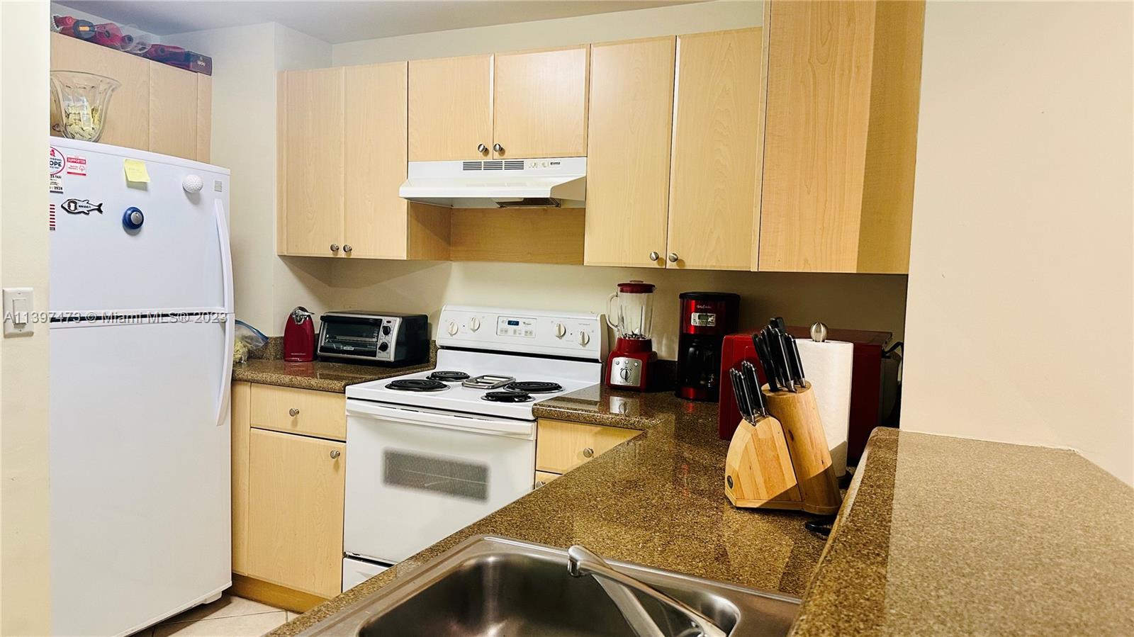 2280 Southwest 32nd Avenue, Unit 315 Miami, FL 33145 - Photo 8 of 21 a kitchen with a stove a refrigerator and cabinets