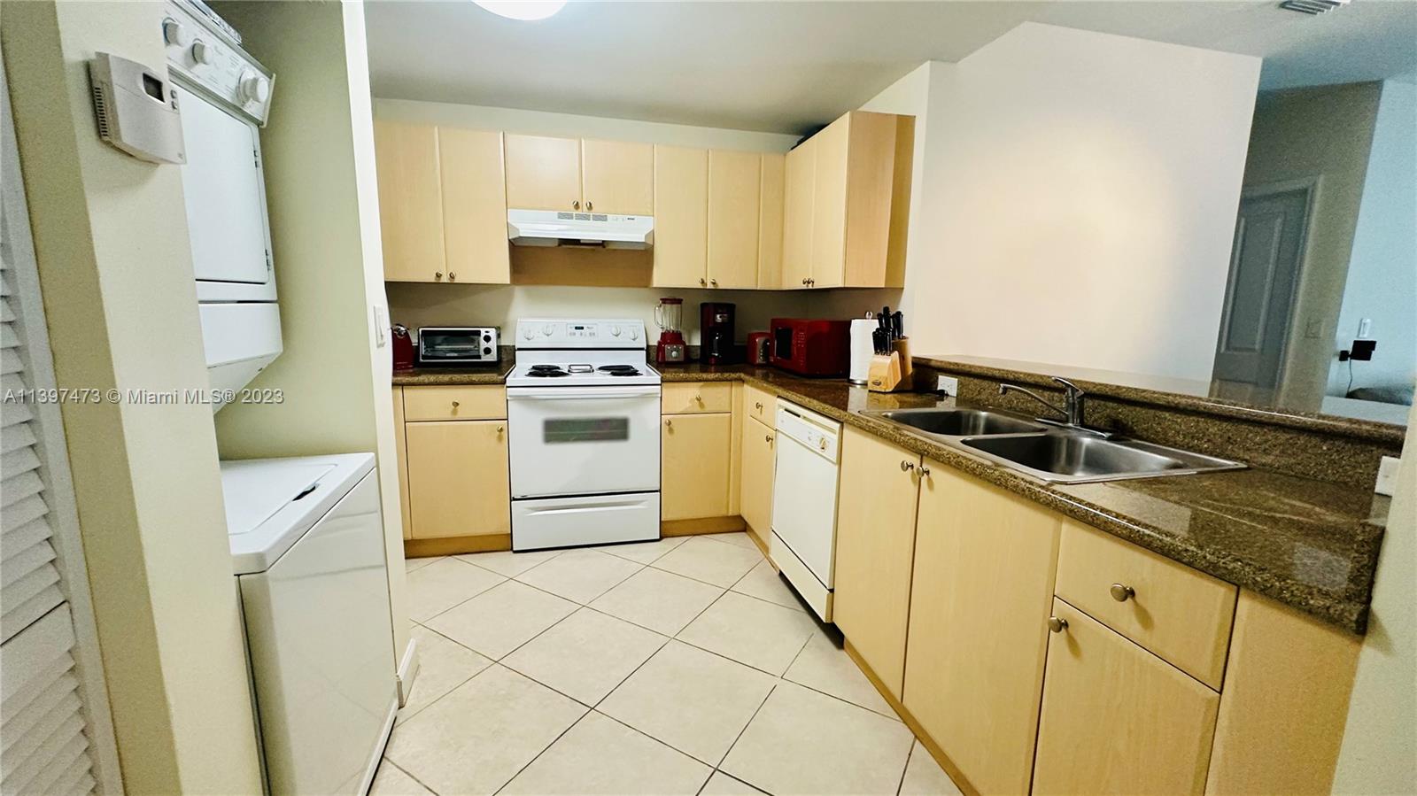 2280 Southwest 32nd Avenue, Unit 315 Miami, FL 33145 - Photo 9 of 21 a kitchen with a sink a stove a refrigerator and cabinets