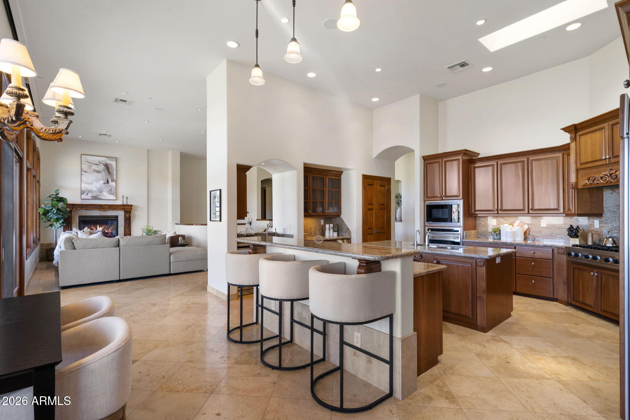 9624 Copper Ridge Trail Fountain Hills, AZ 85268 - Photo 11 of 57 a kitchen with stainless steel appliances granite countertop wooden cabinets a stove a sink a dining table and chairs