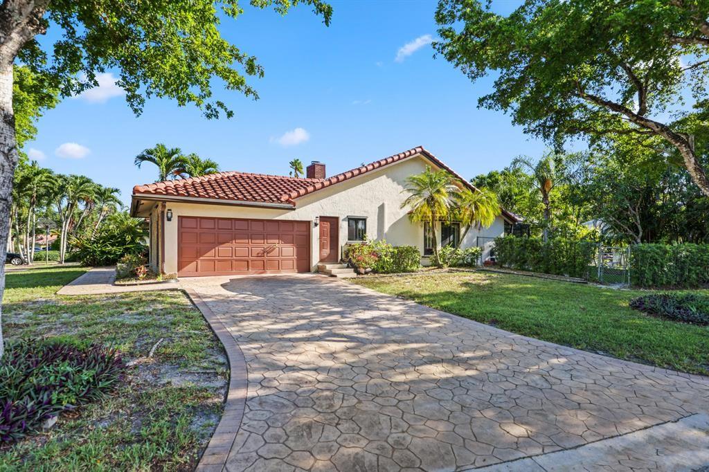 5172 Northwest 84th Road Coral Springs, FL 33067 - Photo 1 of 24 a front view of a house with a garden and yard