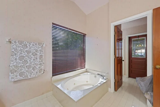 a bathroom with a tub and a large window