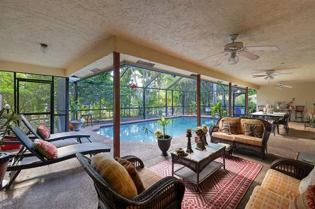 a living room with furniture and floor to ceiling windows